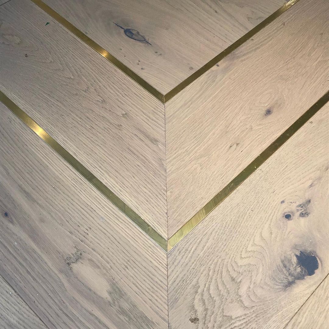 Hardwood flooring with metal inlay strips